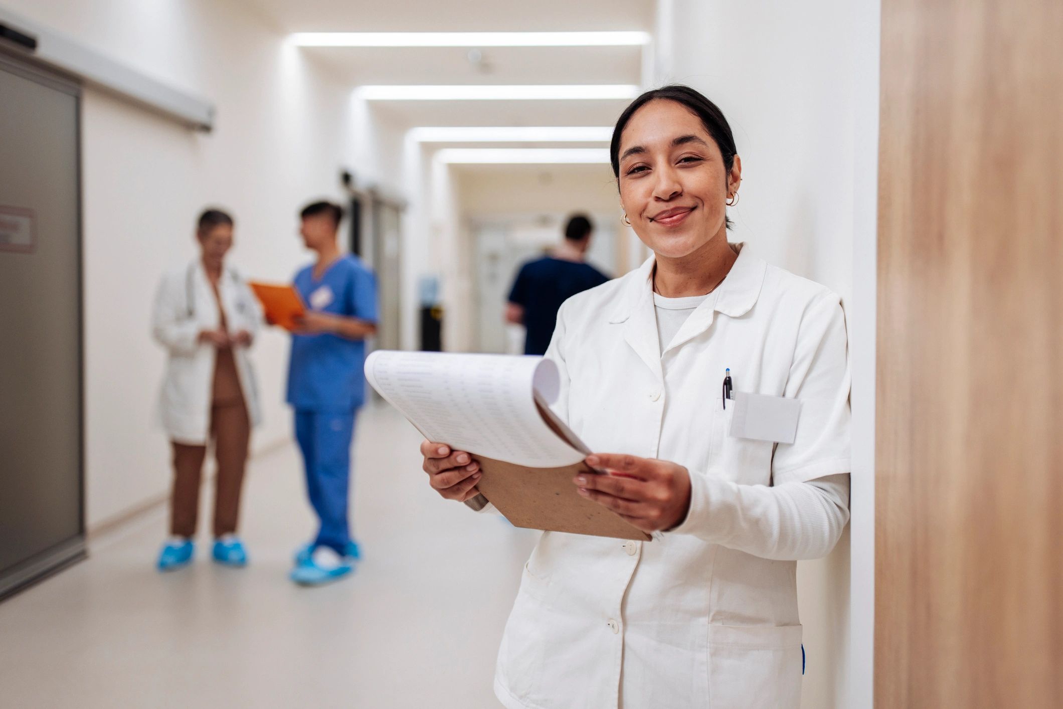 Clinical research coordinator reviewing study documents at a desk in a specialist physician practice