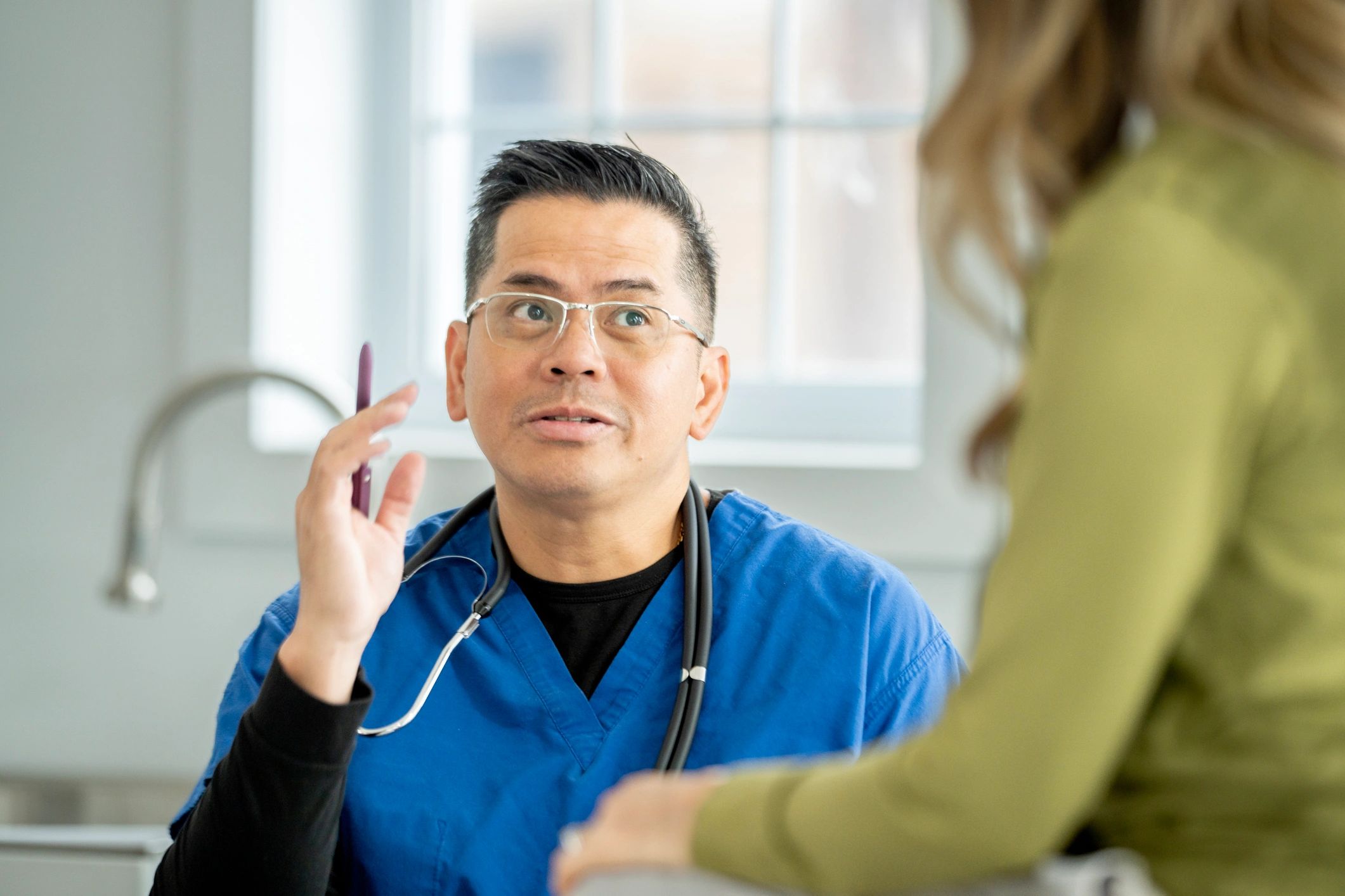 Physician seated with a patient in a modern, well-lit specialist practice consultation setting